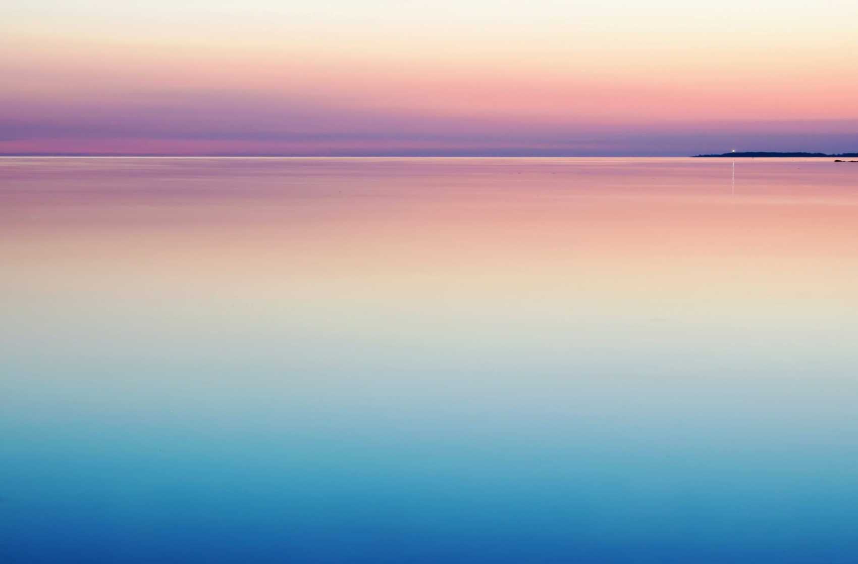 A still lake at sunrise, under a colorful sky