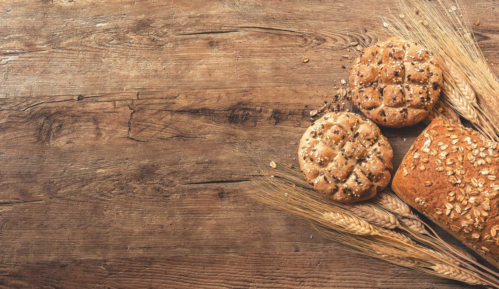 Bread with wheat on cutting board